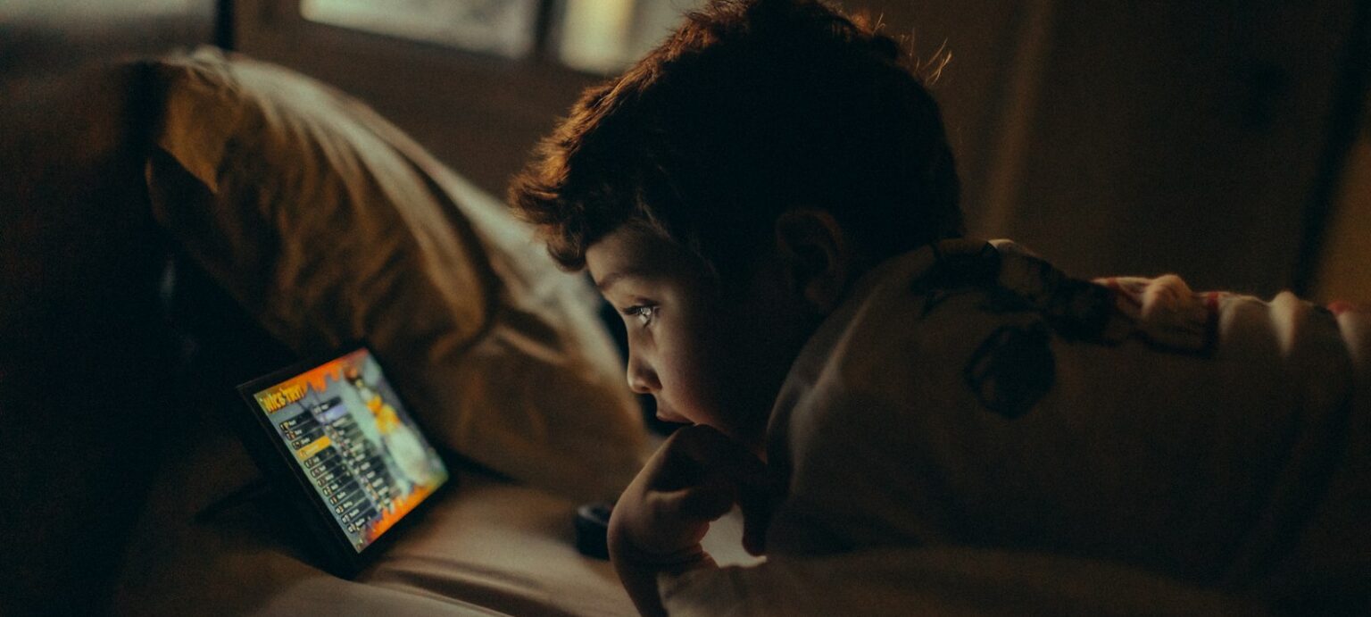 Dečak gleda tablet u krevetu uveče